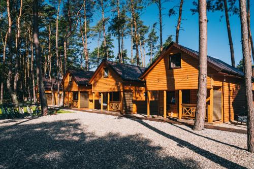 una cabaña de madera en el bosque con muchos árboles en Domki Sekwoja, en Dziwnów