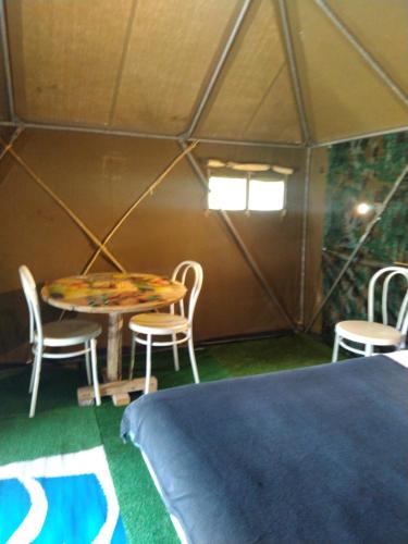 une chambre avec une table et des chaises dans une tente dans l'établissement la tente du commandant français 1954 pour nuit insolite, à Arrest