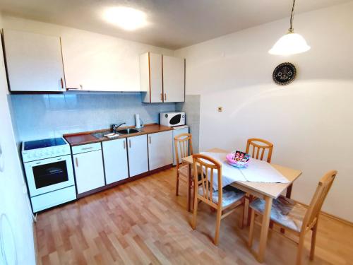 a kitchen with a table and chairs in a room at Apartments Špik in Cerkno