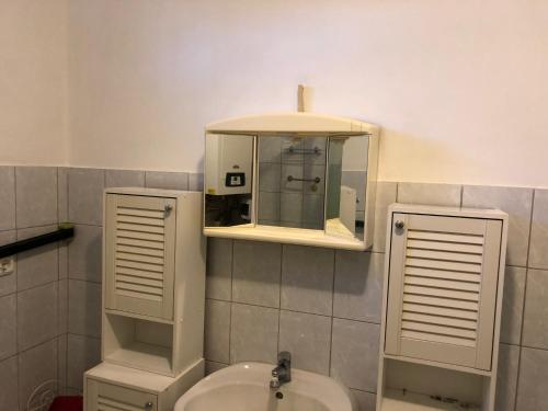 łazienka z umywalką i lustrem w obiekcie Relax Home/Lazit-Lak w mieście Ebergőc