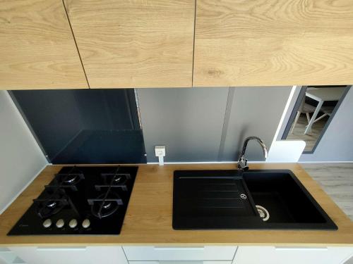 a kitchen counter with a sink and a stove at Garda Di Vino Agricamping & Wine Shop Lazise in Ronchi