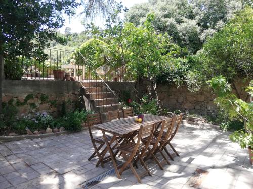 a wooden table and chairs in a garden at B&B San Gregorio SINNAI in San Gregorio