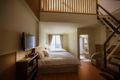 仁愛鄉的住宿－清境春雨行館，一间带大床和楼梯的卧室