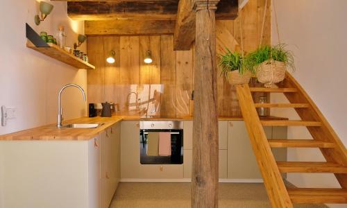 a kitchen with wooden walls and a spiral staircase at Das grüne Haus - Lörrach 