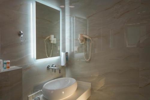 bagno con lavandino e specchio di villa verleti a Párga