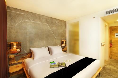 a bedroom with a large bed with two books on it at Greenhost Boutique Hotel Prawirotaman in Yogyakarta