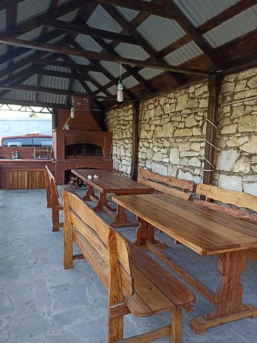 a group of wooden tables and benches in a building at Green Garden in Ijevan
