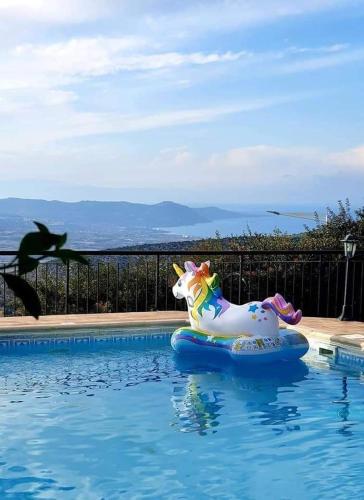 a unicorn float in the water in a swimming pool at Ithaki House in Lyso