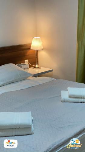 a large white bed with a lamp on a table at Gabrijel Apartments Makarska 1 in Makarska