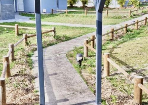 a path in a field next to a wooden fence at Touloukaera appt 303 Plage Kawann in Bon