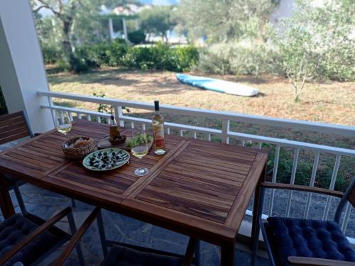 a wooden table on a balcony with a table and chairs at My Mediterranean Villa with Huge Garden and own Parking in Lumbarda