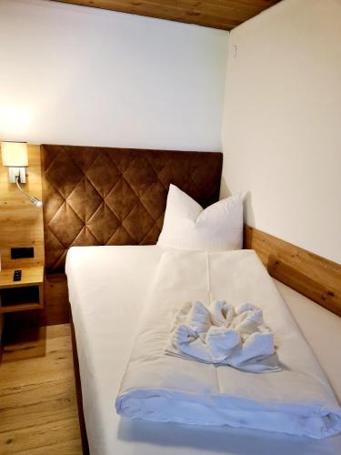 a bed with two towels in the shape of a heart at Hotel Alpenhof*** in Kaltenbach