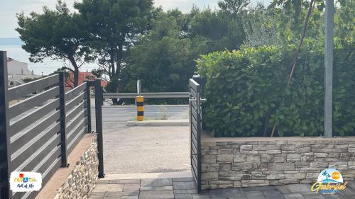 a gate to a driveway with a stone wall at Gabrijel Apartments Makarska 1 in Makarska