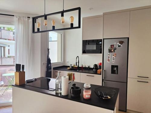 Il comprend une cuisine équipée d'un comptoir noir et d'un réfrigérateur. dans l'établissement Le Zola , au calme en hypercentre avec parking gratuit, à Dijon