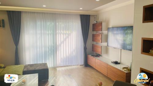 a living room with a large window and a television at Gabrijel Apartments Makarska 1 in Makarska
