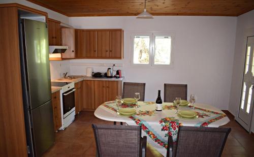 uma cozinha com uma mesa e uma mesa e cadeiras em Cozy cottage with garden and olive grove of 5 acr em Mavráta