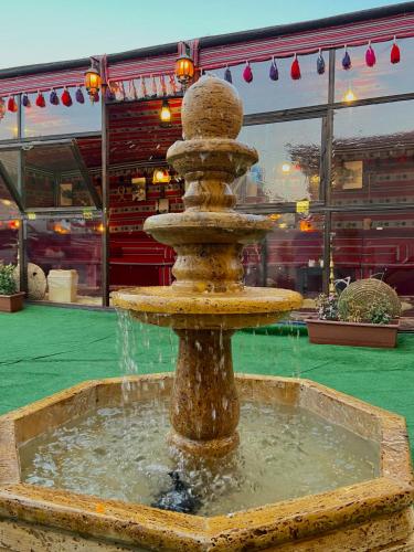 a water fountain in a courtyard with a building at Petra Aretas Hotel in Wadi Musa