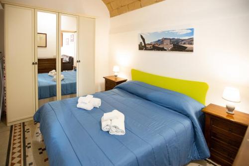 a bedroom with two towels on a blue bed at Fardella 250 in Trapani