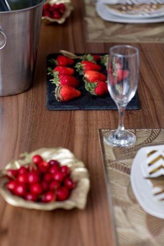 drewniany stół z talerzem truskawek i szklanką wina w obiekcie Prestige w mieście Trebinje