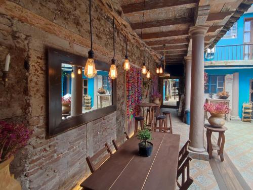 a dining room with a table and chairs and lights at Hostal IKAL in San Cristóbal de Las Casas