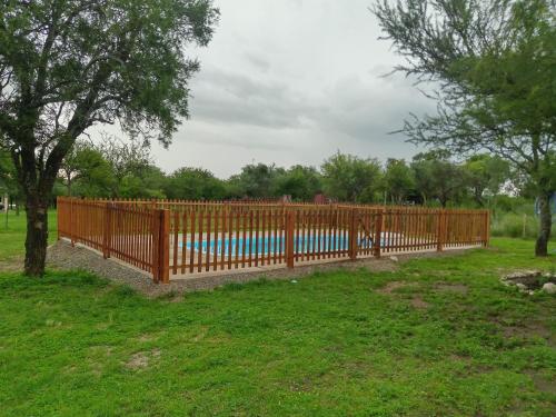 una valla de madera en un patio con piscina en Los Tres Algarrobos en Cortaderas