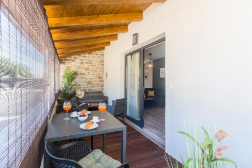 a patio with a table and two glasses of wine at Apartments Residence Radovan 1 in Poreč