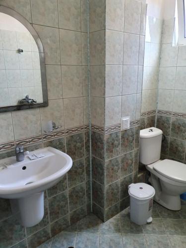 a bathroom with a sink and a toilet and a mirror at Villa Amadeus in Nesebar
