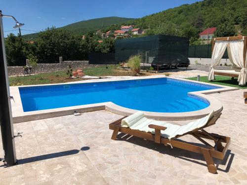 a swimming pool with two lounge chairs next to it at Villa Emili in Posušje