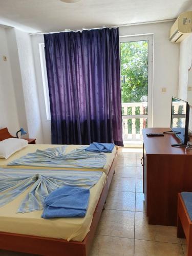 a bedroom with a bed and a desk and a window at Villa Amadeus in Nesebar