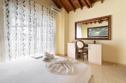 a bedroom with a bed and a desk and a window at Apartments Alexandros in Polykhrono