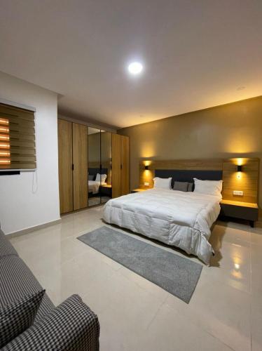 una grande camera da letto con un grande letto e un divano di CasaHouse Apparts a Nouakchott