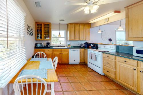 a kitchen with wooden cabinets and a table and a table and chairs at Happy Ours in Salvo