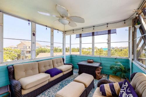 a screened in porch with a couch and windows at Happy Ours in Salvo