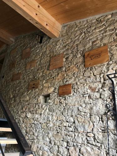 a stone wall with wooden signs on it at Séjour LUXE pour couple avec PISCINE INTÉRIEURE terrasse SPA privé Green de GOLF in Alzonne