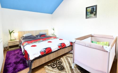 a bedroom with a bed with a red and white comforter at Natura hause in Rakovica