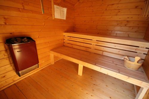 a wooden sauna with a bench and a trash can at Spa Chalets In Olive Grove in Eli Ad