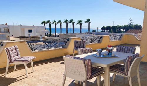 a table and chairs on a balcony with a view of the ocean at Torre Vado Appartamento Vista Mare in Torre Vado