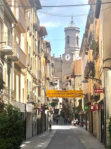 a city street with a clock tower in the distance at Precioso piso en el centro neurálgico de Olot in Olot
