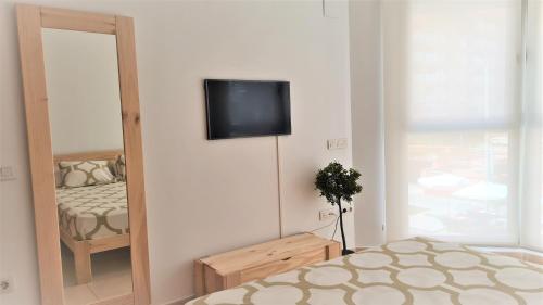 um quarto com uma cama e uma televisão na parede em BEACH VALENCIA 21 - Luxury Apartament on Beach em Valência