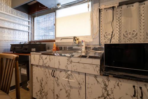 una cucina con lavandino e forno a microonde di Unique joy House a Okayama