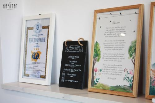 a shelf with three signs and a chalkboard sign at Habitat Central Apartment in Ruse