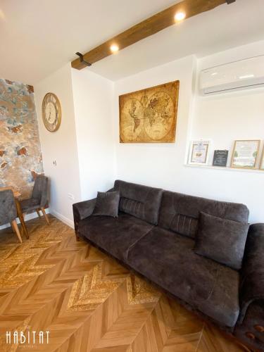 a living room with a brown leather couch at Habitat Central Apartment in Ruse