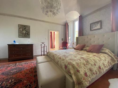 a bedroom with a large bed and a dresser at Les Dames de Saint Florent in Saint-Florent-sur-Auzonnet