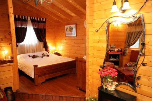 a bedroom with a bed in a log cabin at Spa Chalets In Olive Grove in Eli Ad
