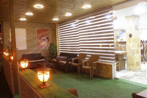 a restaurant with a waiting room with chairs and a table at Petra Aretas Hotel in Wadi Musa