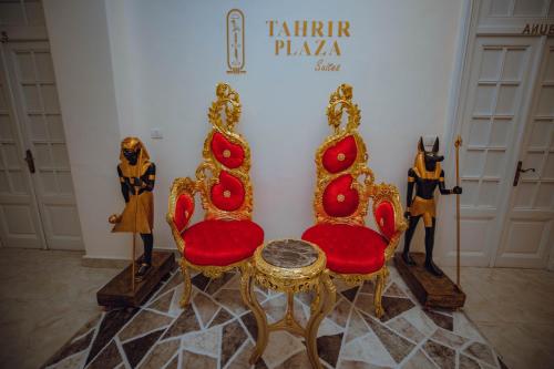 a room with two chairs and a table in front of a wall at Tahrir Plaza Suites - Museum View in Cairo