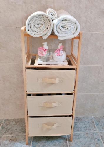 a wooden shelf with three drawers in a bathroom at Cozy cottage with garden and olive grove of 5 acr in Mavráta