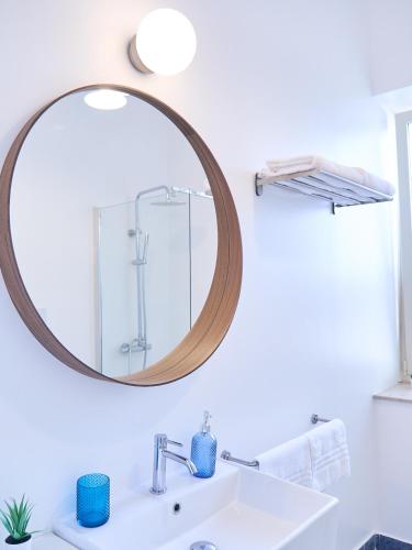 a bathroom with a mirror and a sink at Qurchiti in Capo dʼOrlando