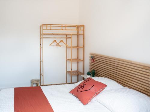 une chambre avec un lit avec un oreiller rouge dessus dans l'établissement L'HACIENDA CHAMPENOISE, à Châlons-en-Champagne