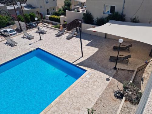 an overhead view of a pool with chairs and a table at Gorgeous SeaView house in Pissouri